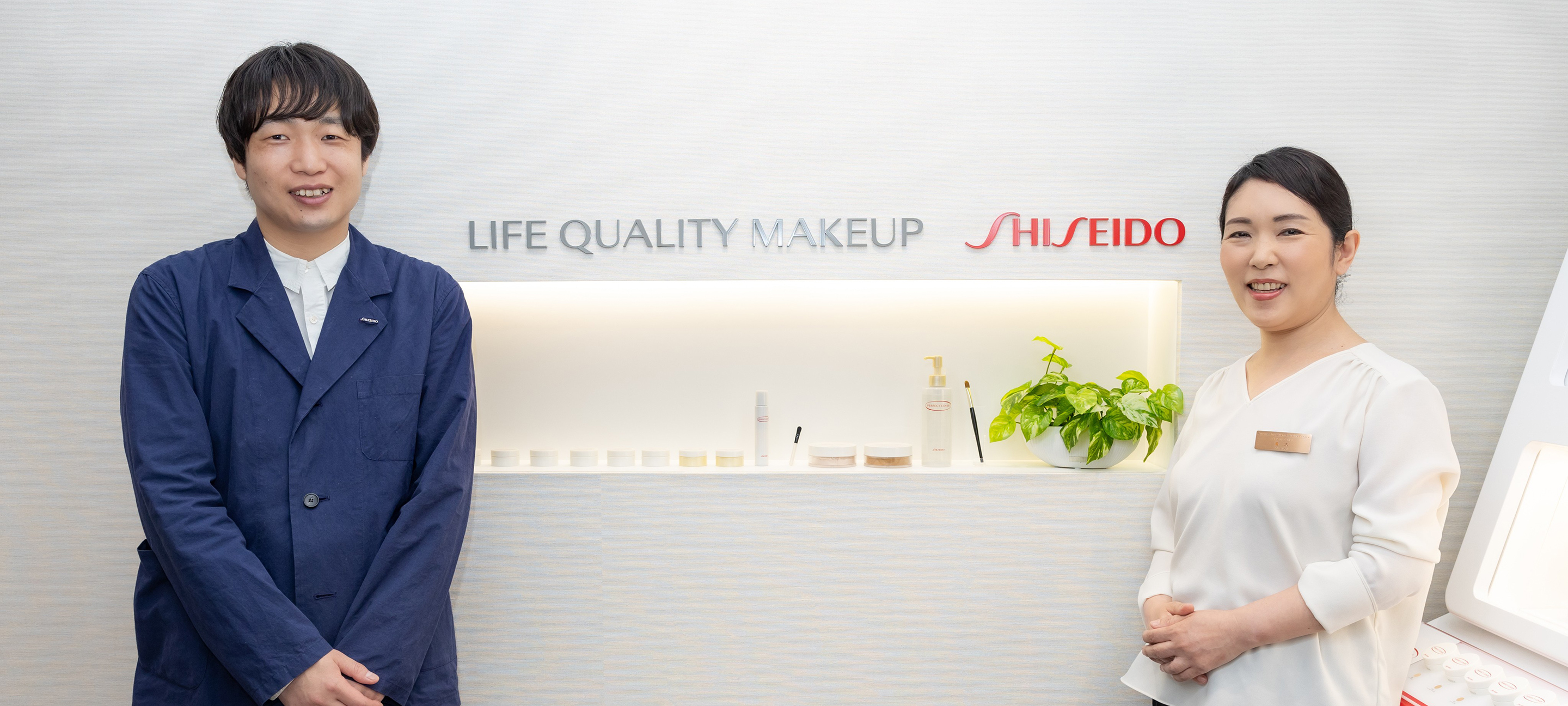 Shiseido employees Ozawa and Aoki stand side by side, smiling, with the Shiseido Life Quality Beauty Center logo in the background.