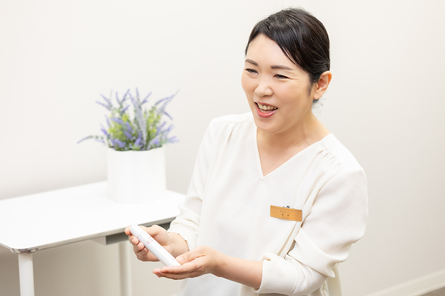 Aoki speaking with a smile while holding a Perfect Cover product.