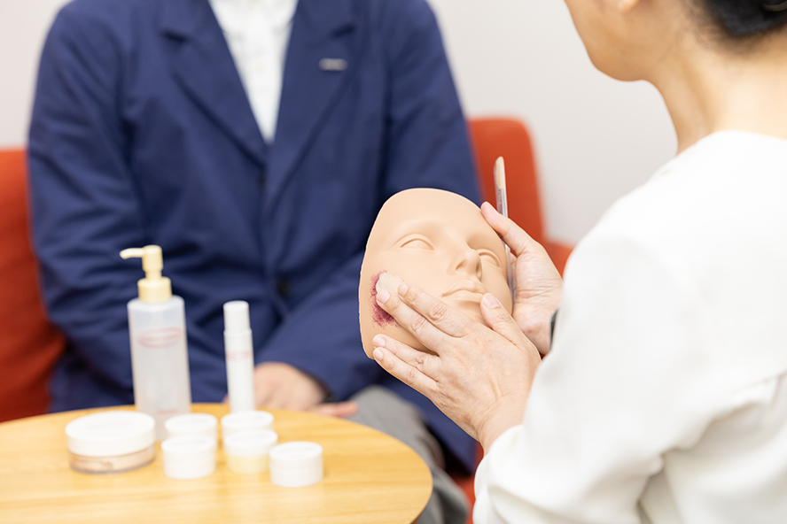 Aoki demonstrates how to use Perfect Cover by applying it to a mannequin with a birthmark.