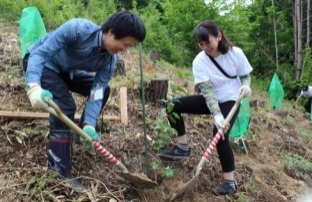 A city office worker and a Shiseido employee planting a nursery tree 
