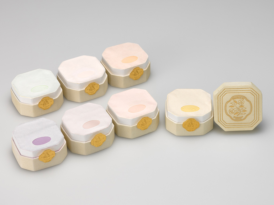 1917年に資生堂が発売した「着色福原粉白粉七種（七色粉白粉）」の画像。7色の白粉が、1色ずつ正方形の四すみを直線で切った八角形の容器に入っている。
