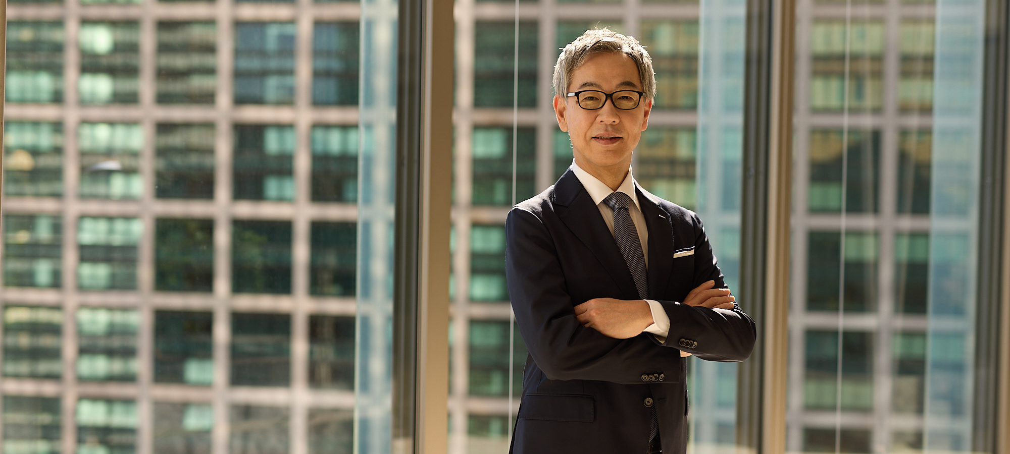 腕を組み微笑む資生堂社長CEOの藤原憲太郎