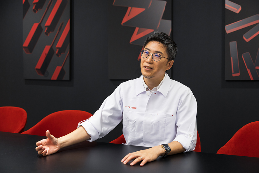 椅子に座り、笑顔で語る小橋