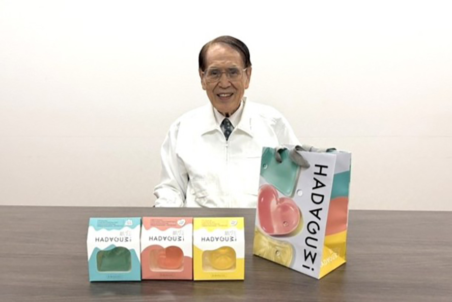 ホネケーキ社の仁科さんがテーブルに着席し、肌グミを前に置いて笑顔を向けている